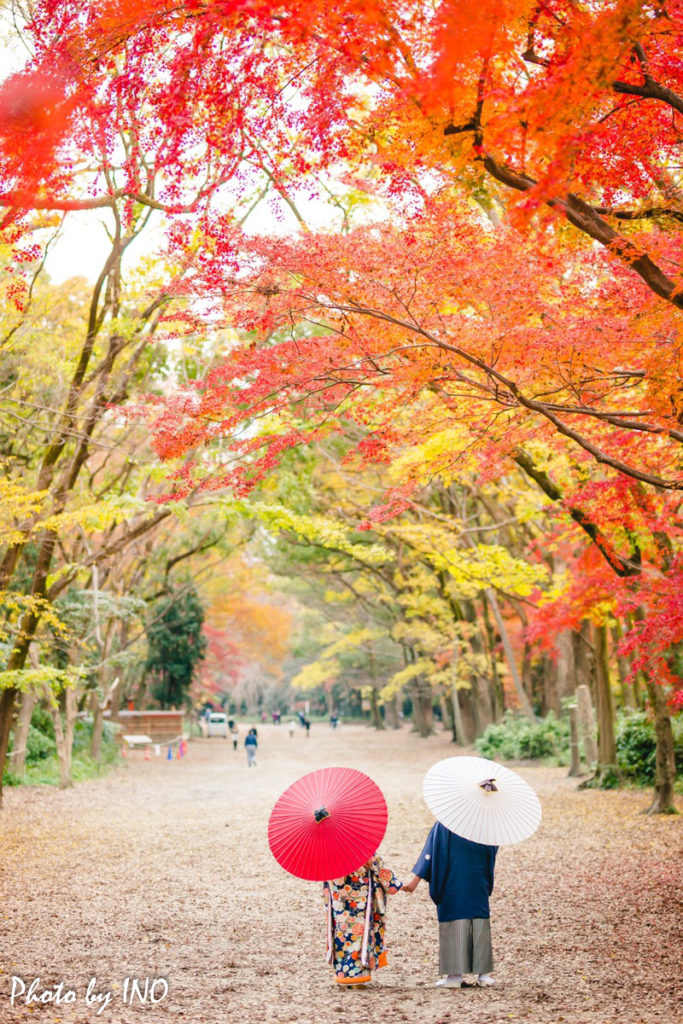 紅葉の時期に下鴨神社で番傘を指しながら歩く新郎新婦の前撮り
