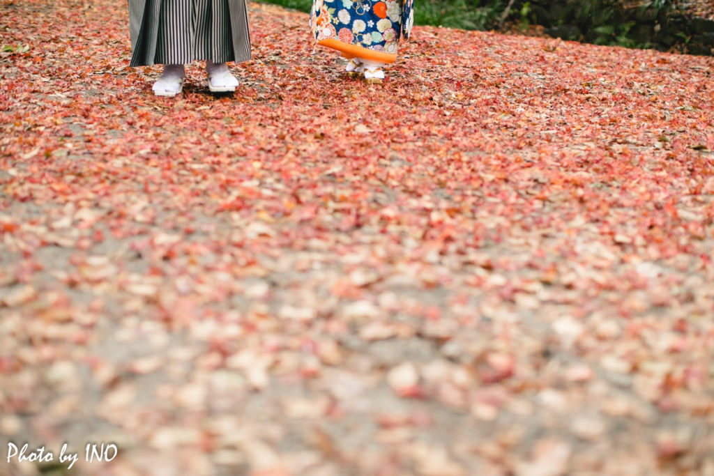 紅葉の時期に下鴨神社で番傘を指しながら歩く新郎新婦の前撮りの足元